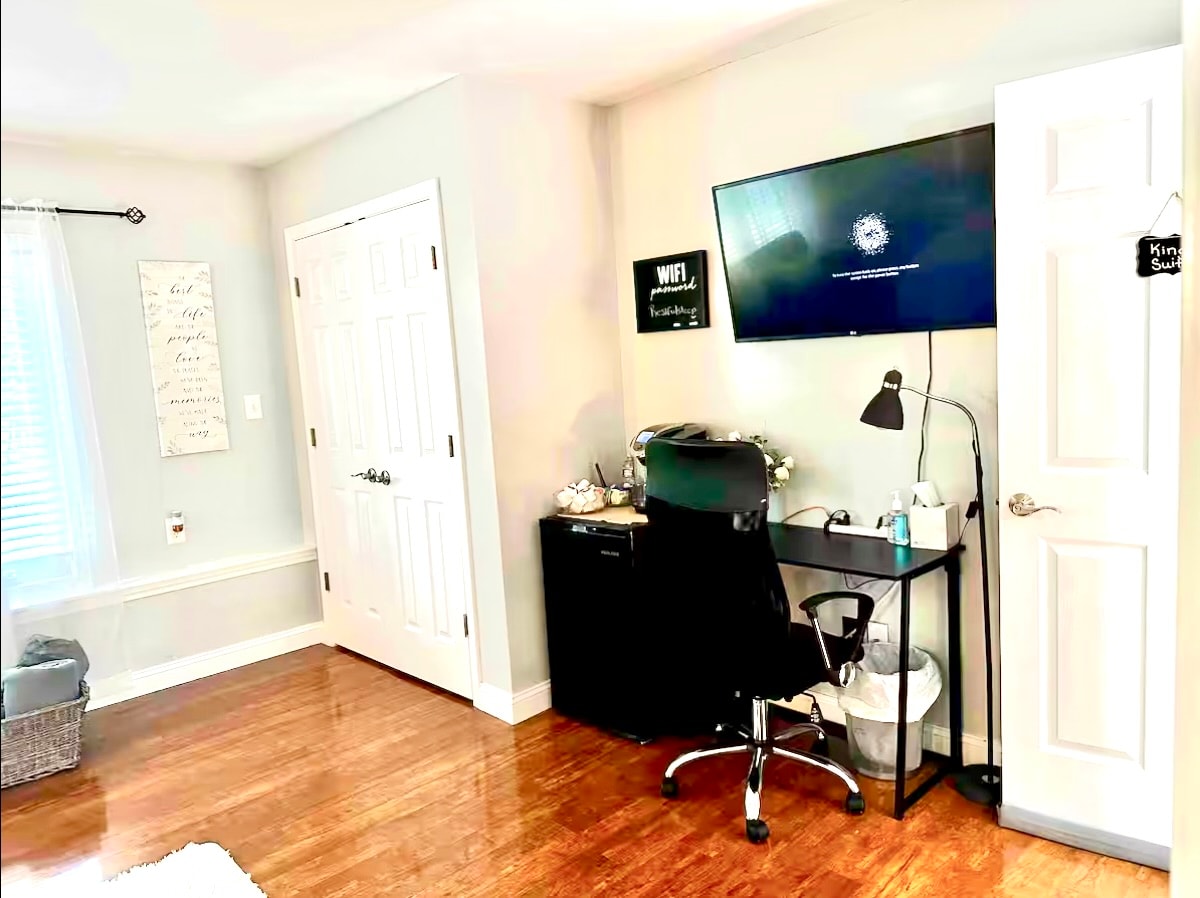 Desk, smart TV, and workspace in a king bedroom